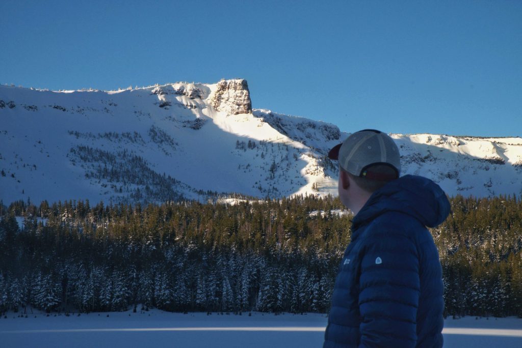 Man overlooking Three Sisters Mountain while backcountry skiing