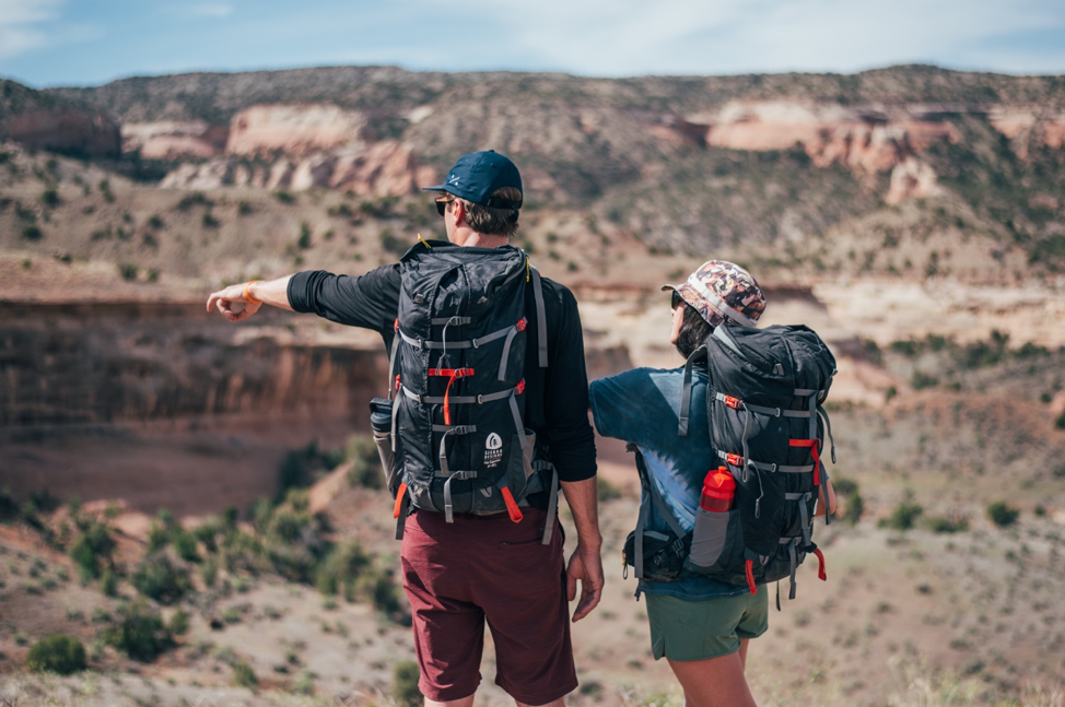 A picture containing two people, mountains, backpacking, hiking
